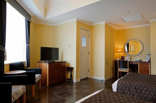 a hotel room with a bed and a television at Hotel Monterey La Soeur Fukuoka in Fukuoka