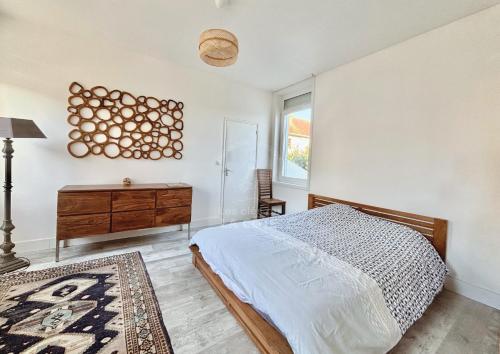 a bedroom with a bed and a desk and a window at Le Refuge du Port in Étaples