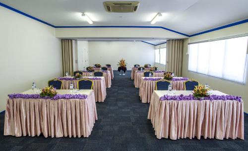 a row of tables in a room with purple flowers at Heritage Park Hotel in Honiara