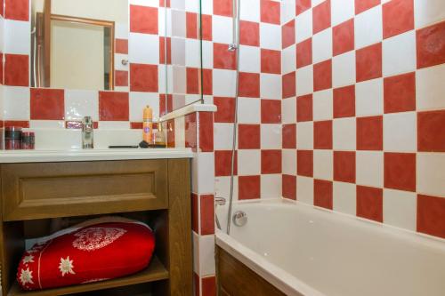 baño con pared de cuadros rojo y blanco en Résidence Goélia Les Chalets Valoria, en Valloire