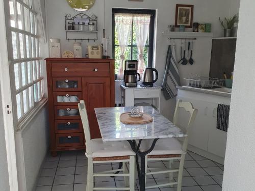 eine Küche mit einem Tisch und Stühlen in einer Küche in der Unterkunft La Maison de Jeanne in Lesparre-Médoc