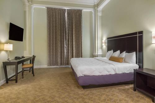 Großes Hotelzimmer mit einem Bett und einem Schreibtisch. in der Unterkunft The Gin Hotel, an Ascend Collection Hotel in Lexington