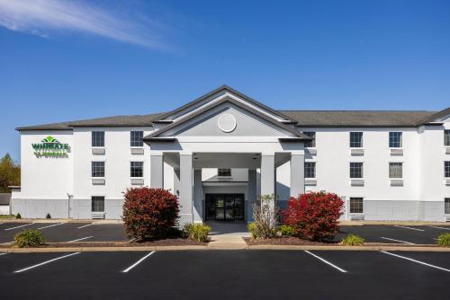 a large white building with a parking lot at Wingate by Wyndham Grove City in Grove City