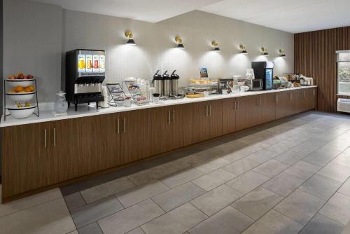 ein Restaurant mit einem Tresen mit einem aasteryasteryasteryasteryasteryasteryasteryasteryasterja in der Unterkunft Wingate by Wyndham Grove City in Grove City
