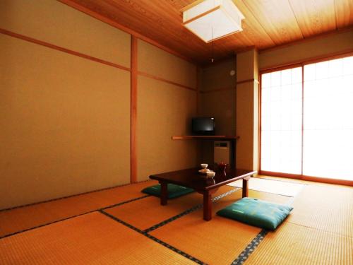 uma sala de estar com uma mesa e uma janela em Chouchinya em Nozawa Onsen
