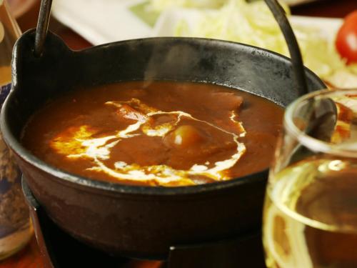 a pot of soup next to a glass of wine at Chouchinya in Nozawa Onsen