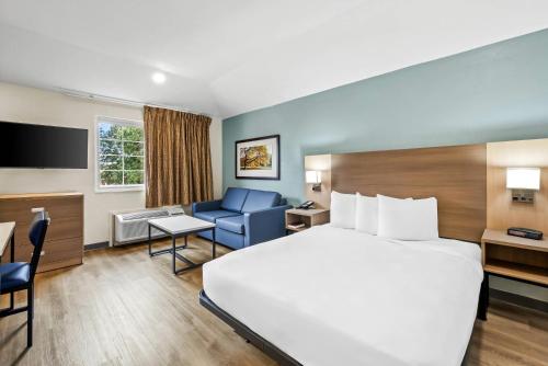 ローリーにあるMainStay Suites Raleigh Northの大きなベッドと机があるホテルの部屋