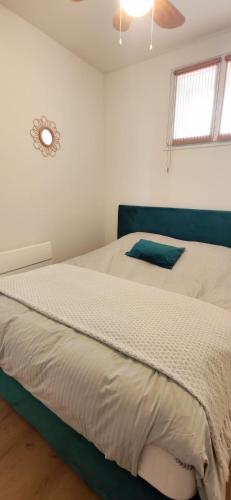 a bedroom with a large bed with a clock on the wall at Bright apartment in Menton in Menton