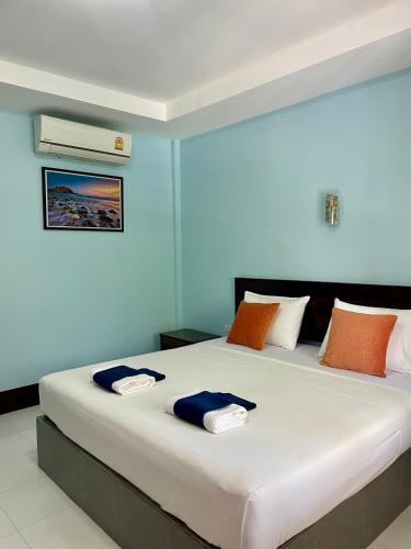 a bedroom with a large white bed with orange and blue pillows at Lanta Salamat House in Ko Lanta