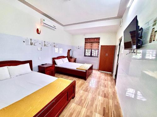 a bedroom with a bed and a couch and a tv at Nhà Nghỉ Thành Duy in Quang Ngai