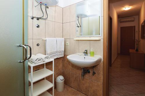 a bathroom with a sink and a mirror at Apartments Lucija in Sukošan
