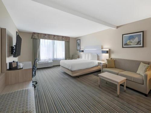 a hotel room with a bed and a couch at Best Western Plus Twin View Inn & Suites in Redding