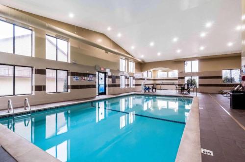 a large swimming pool with blue water in a building at Comfort Inn & Suites University South in Ann Arbor