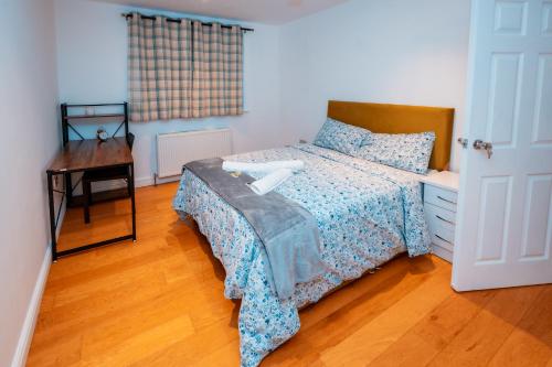 a bedroom with a bed and a desk and a bed with a bedspread at Cozy room in yellow in Sale