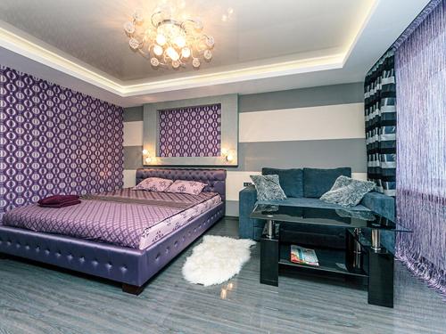 a bedroom with a purple bed and a couch at Hotrent City in Kyiv