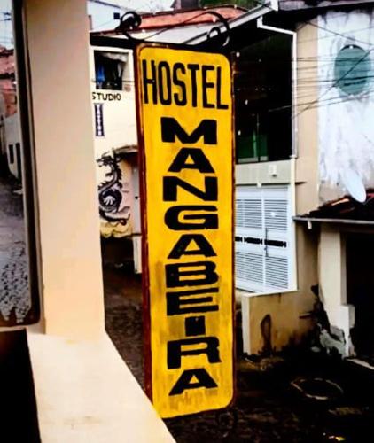 a yellow hotel sign on the side of a building at Hostel Mangabeira in Cachoeira