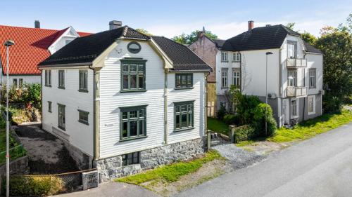 una casa blanca al costado de una calle en Brekkehagen, en Skien