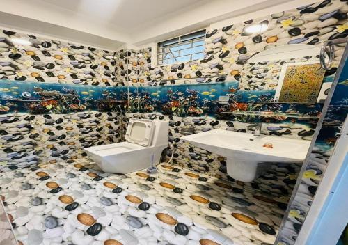 a bathroom with a toilet and a sink at Aadhira Guest House in Trincomalee