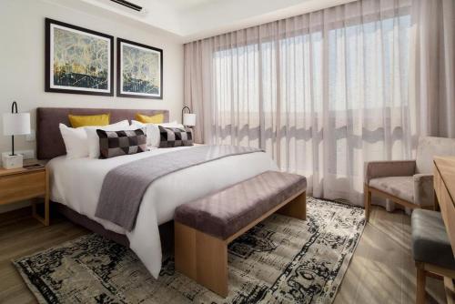 a bedroom with a large bed and a large window at Cosy Regency menylin apartment in Pretoria