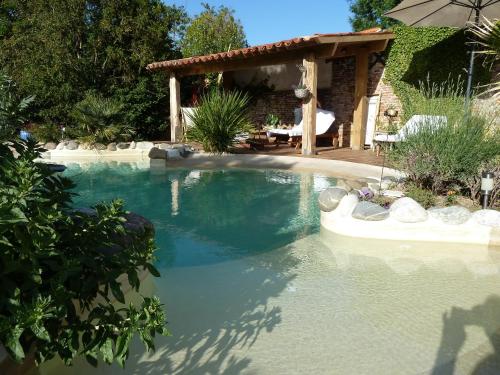 una piscina en un patio con una casa en Maison Le Village 4 épis, en Villenouvelle
