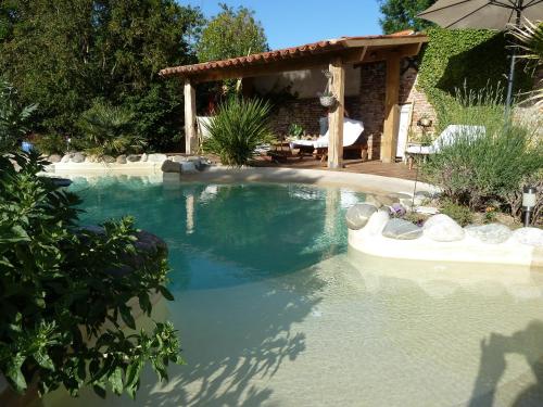 a swimming pool in a yard with a house at Domaine Le Village in Villenouvelle