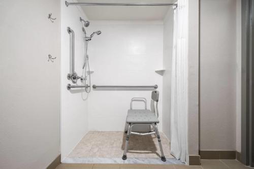 a chair in a bathroom with a shower at Days Inn by Wyndham Murphy in Murphy