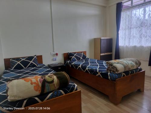 a bedroom with two beds and a couch at Adoreen Homestay in Cherrapunji