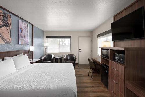 a hotel room with a bed and a flat screen tv at Days Inn by Wyndham Prescott in Prescott
