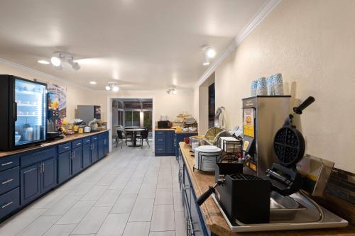 Una cocina grande con gabinetes azules y un televisor. en Days Inn by Wyndham Prescott, en Prescott