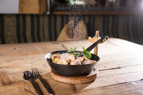 a bowl of food on a wooden table at Hotel Eden in Tux