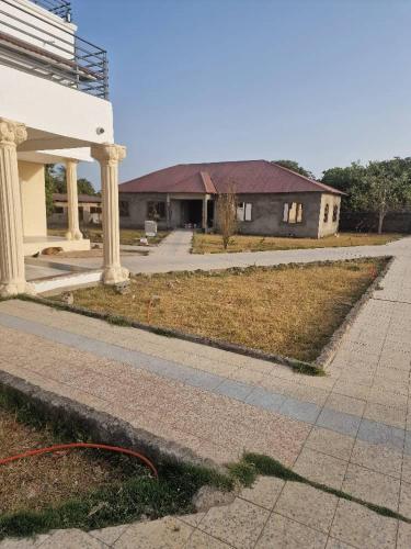 a house with a road in front of a house at Rayana's Busura BnB in Brikama