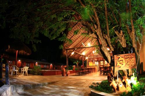 a building with a tree with a sign on it at Pousada Peixe Galo in Galinhos