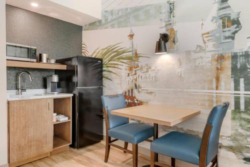 une cuisine avec une table, des chaises et un réfrigérateur dans l'établissement Cambria Hotel Tampa-Brandon, à Tampa