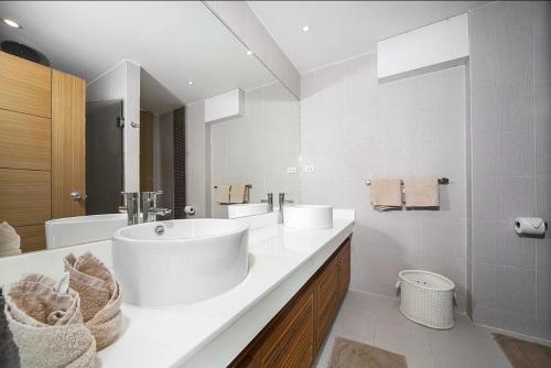 Un baño blanco con una bañera grande y un lavabo. en Villa with private pool in Kamala, en Kamala Beach