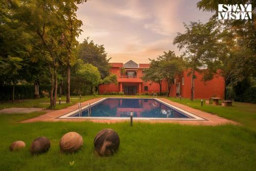 une maison avec une piscine dans la cour dans l'établissement StayVista at Petals Of Dusk - Outdoor pool, WiFi & BBQ, à Jaipur