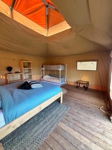 a bedroom with a bed in a tent at Safari Lodge at Back to Basic in Zwaanshoek