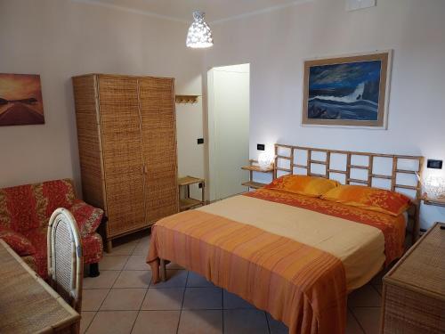 ein Schlafzimmer mit einem Bett und einem Stuhl in der Unterkunft Relais Frantoio delle Pietre in Conversano