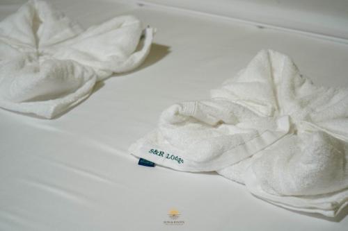 a pair of white towels sitting on a bed at Sun & Roots Kampot Lodge in Kampot