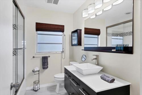 a bathroom with a sink and a toilet and a mirror at Charming 3BR Retreat Near Sarasota Beaches in Sarasota