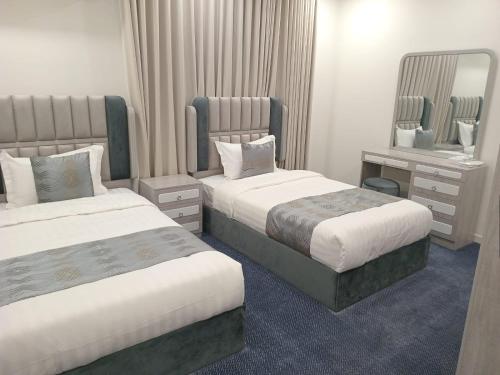 een hotelkamer met twee bedden en een spiegel bij فيلمست ريزيدنس ابهاVelmist Residence Abha in Abha