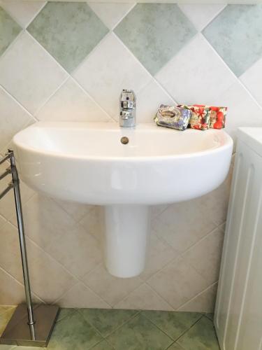 a white sink in a bathroom with tiles at Appartamento Aprica 2.0 in Aprica