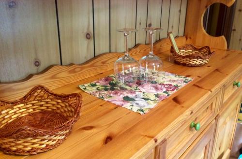 a wooden table with two wine glasses on top of it at Appartamento Aprica 2.0 in Aprica