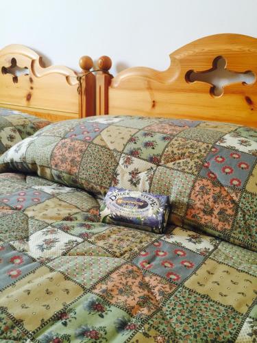 a bed with a quilt and a pillow on it at Appartamento Aprica 2.0 in Aprica