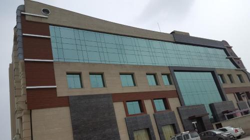 a building with glass windows on the side of it at Park Blu in Sonīpat
