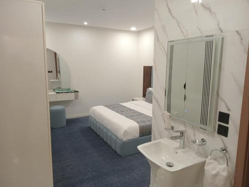 een badkamer met een bed, een wastafel en een spiegel bij فيلمست ريزيدنس ابهاVelmist Residence Abha in Abha
