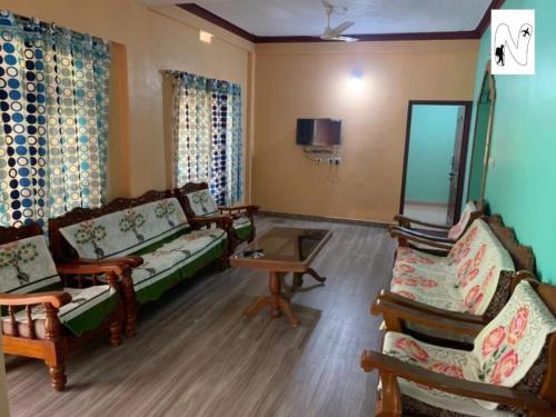 ein Wohnzimmer mit zwei Sofas und einem Tisch in der Unterkunft Coffee Voyages in Madikeri