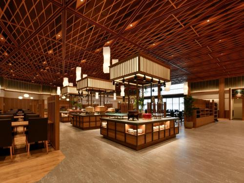 a lobby with a restaurant with tables and chairs at jyozankei SHIKAnoYU in Jozankei