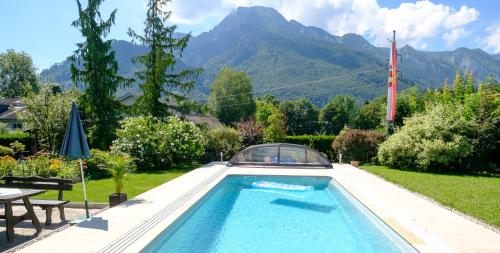 a swimming pool in a garden with mountains in the background at Haus am Moos in Salzburg