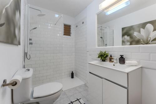 a white bathroom with a toilet and a sink at Eva The View in Puerto de Santiago