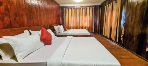 a bedroom with two beds with white and red pillows at Sun Hostel and Restaurant Kampot in Kampot